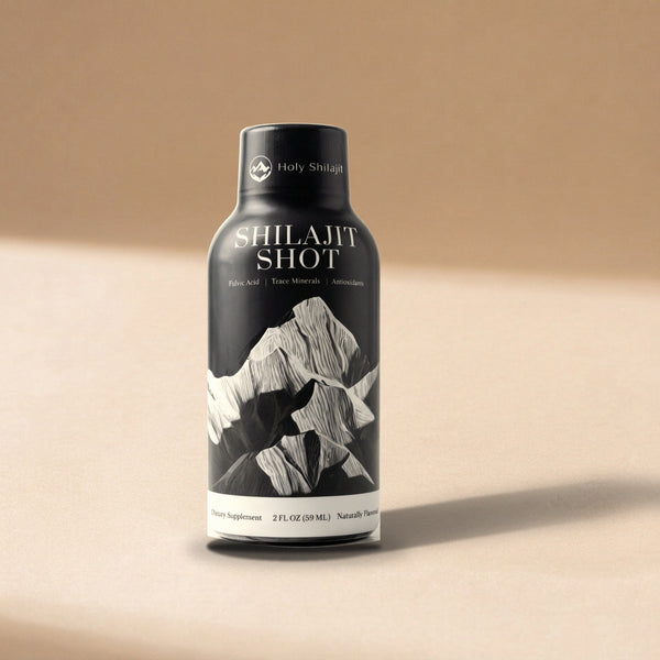 Holy Shilajit Shilajit Shot bottle standing on a warm tan tabletop in soft window light